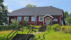 Ett rödmålat hus med grått tak och texten bygdegård på fasaden