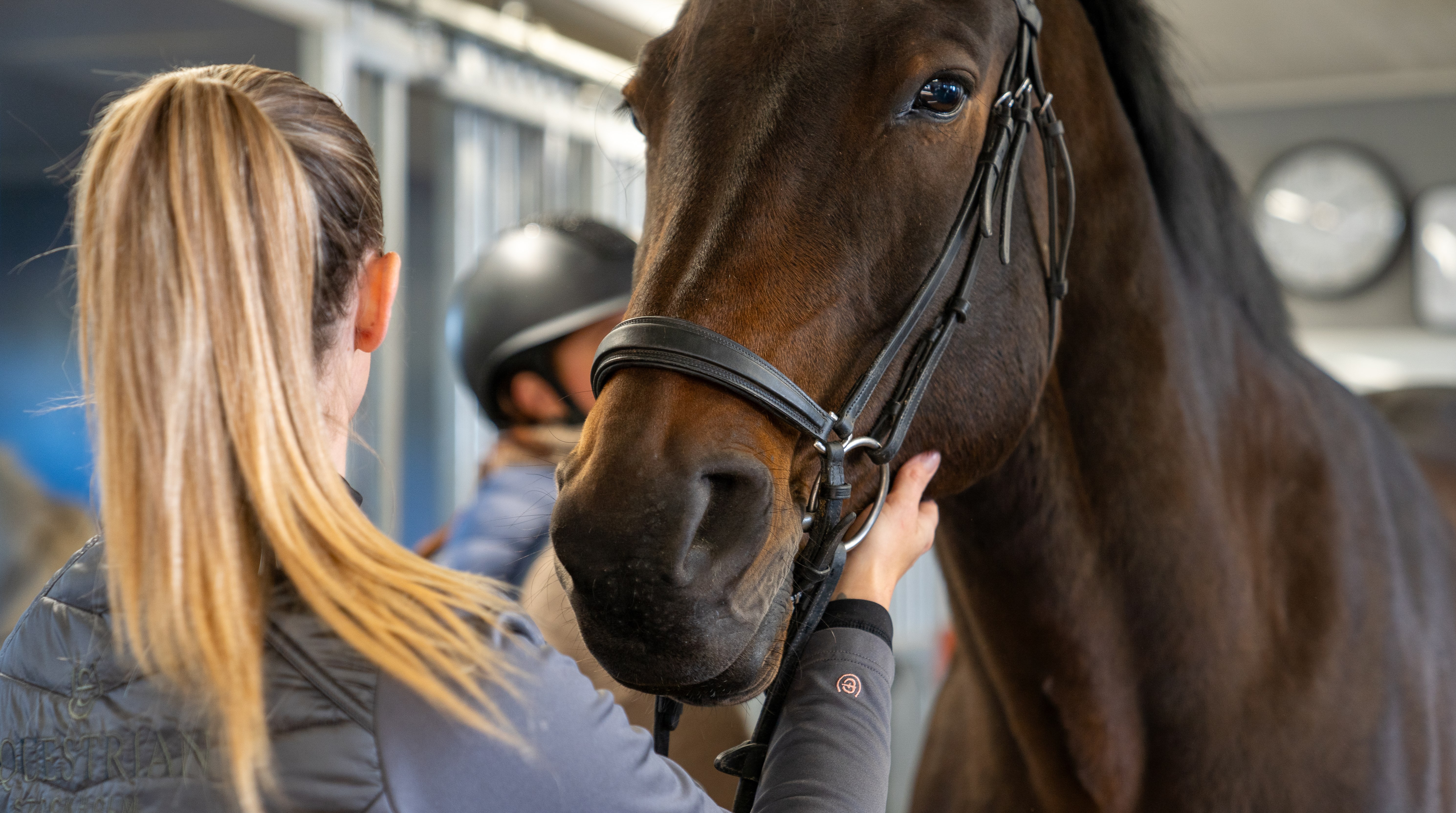 Två elever tar hand om en häst