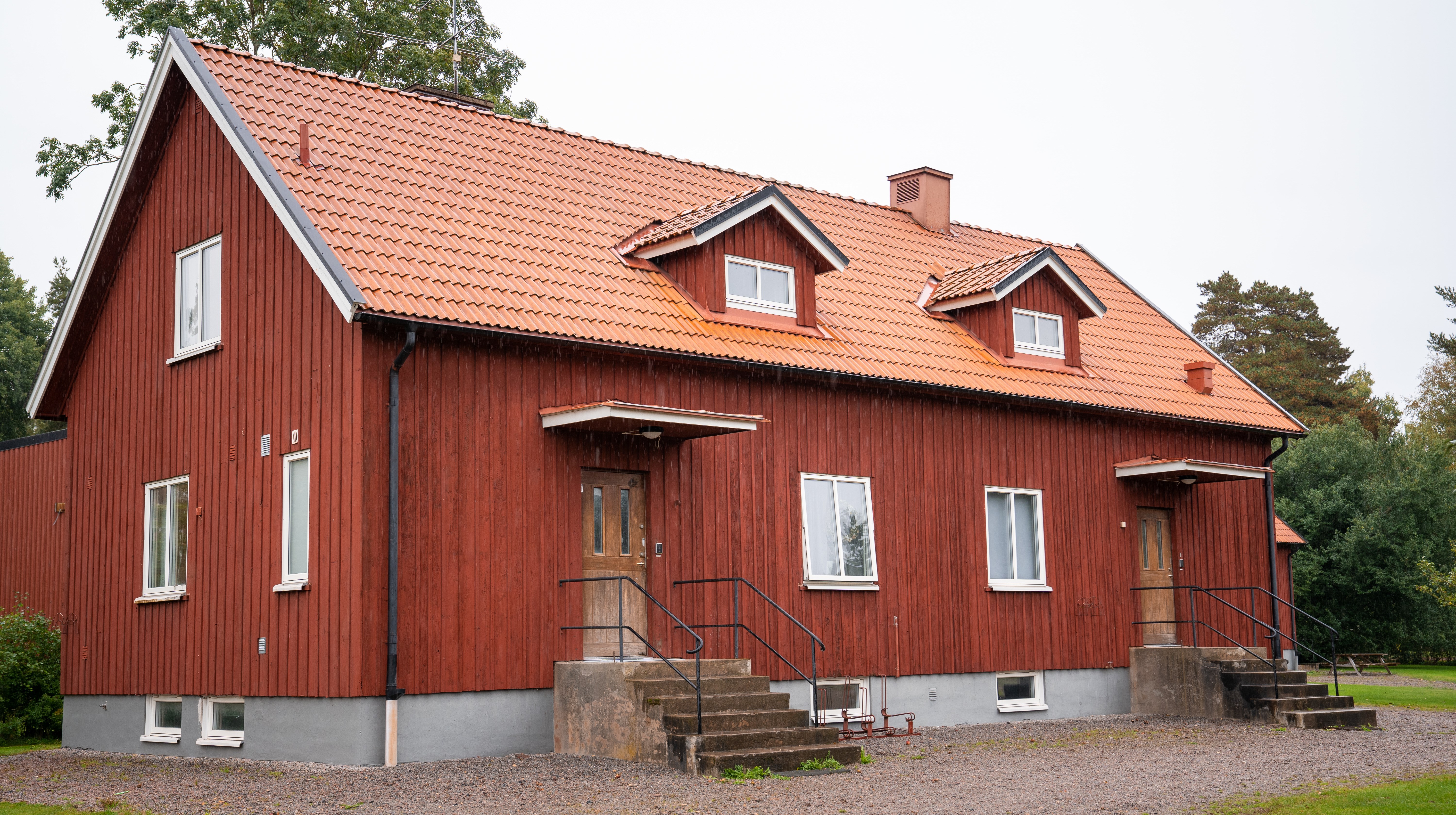 Internatbyggnad med två ingångar, röd panel och tegeltak