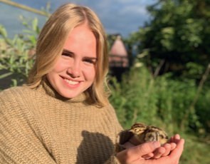 Jennifer Jacobsson som håller i en fågelunge