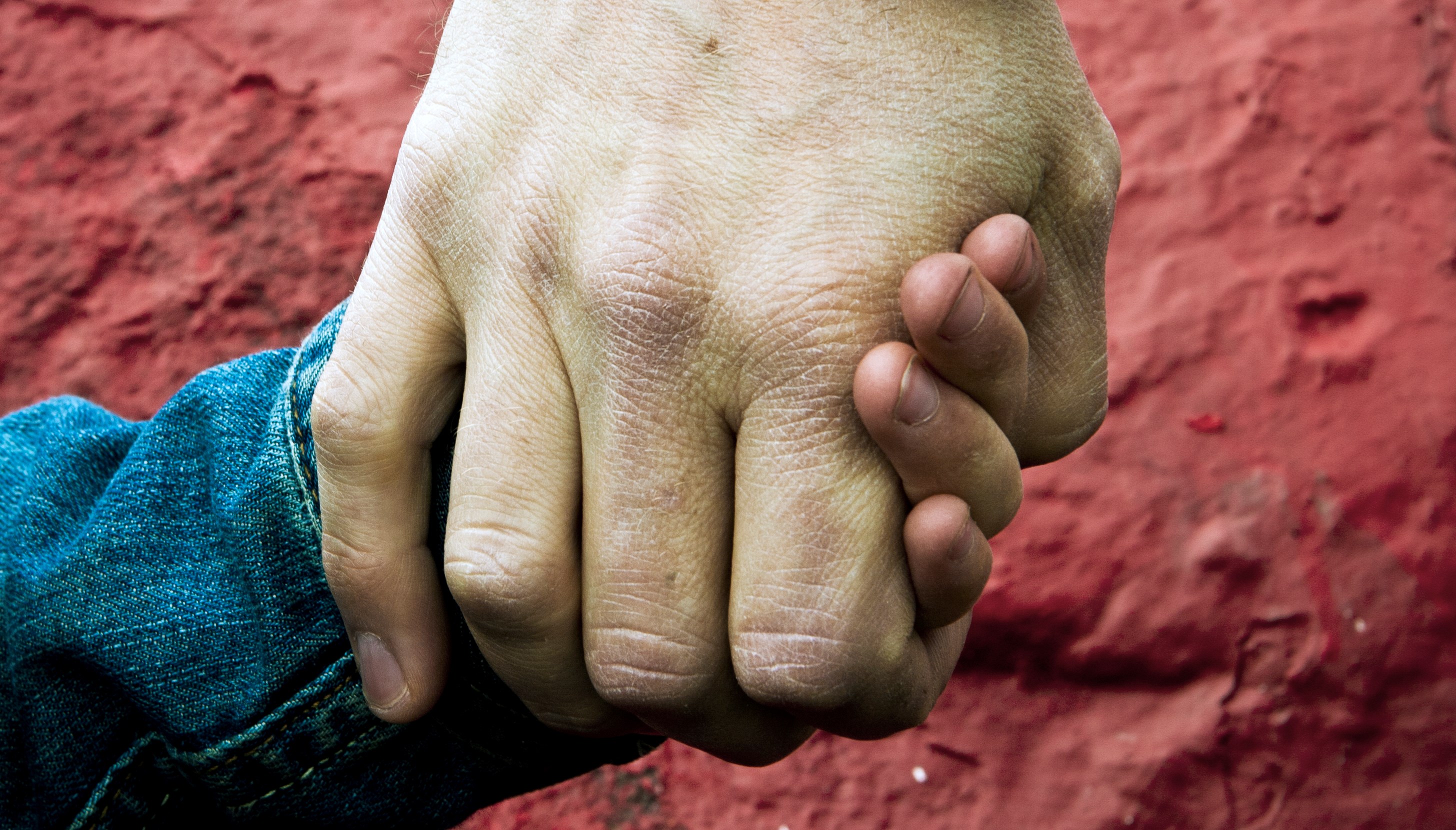 en barnhand håller i en vuxen hand