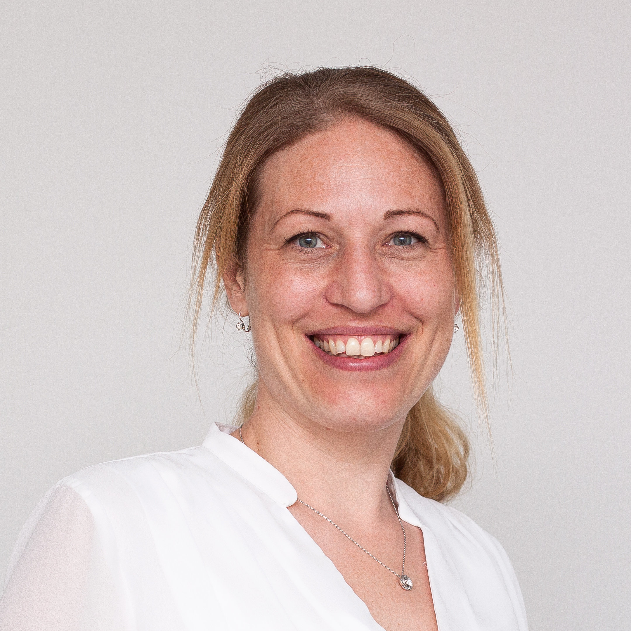 leende kvinna mot vit bakgrund