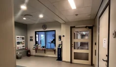 Reception med glasfönster, anslagstavla till vänster och klocka ovanför.