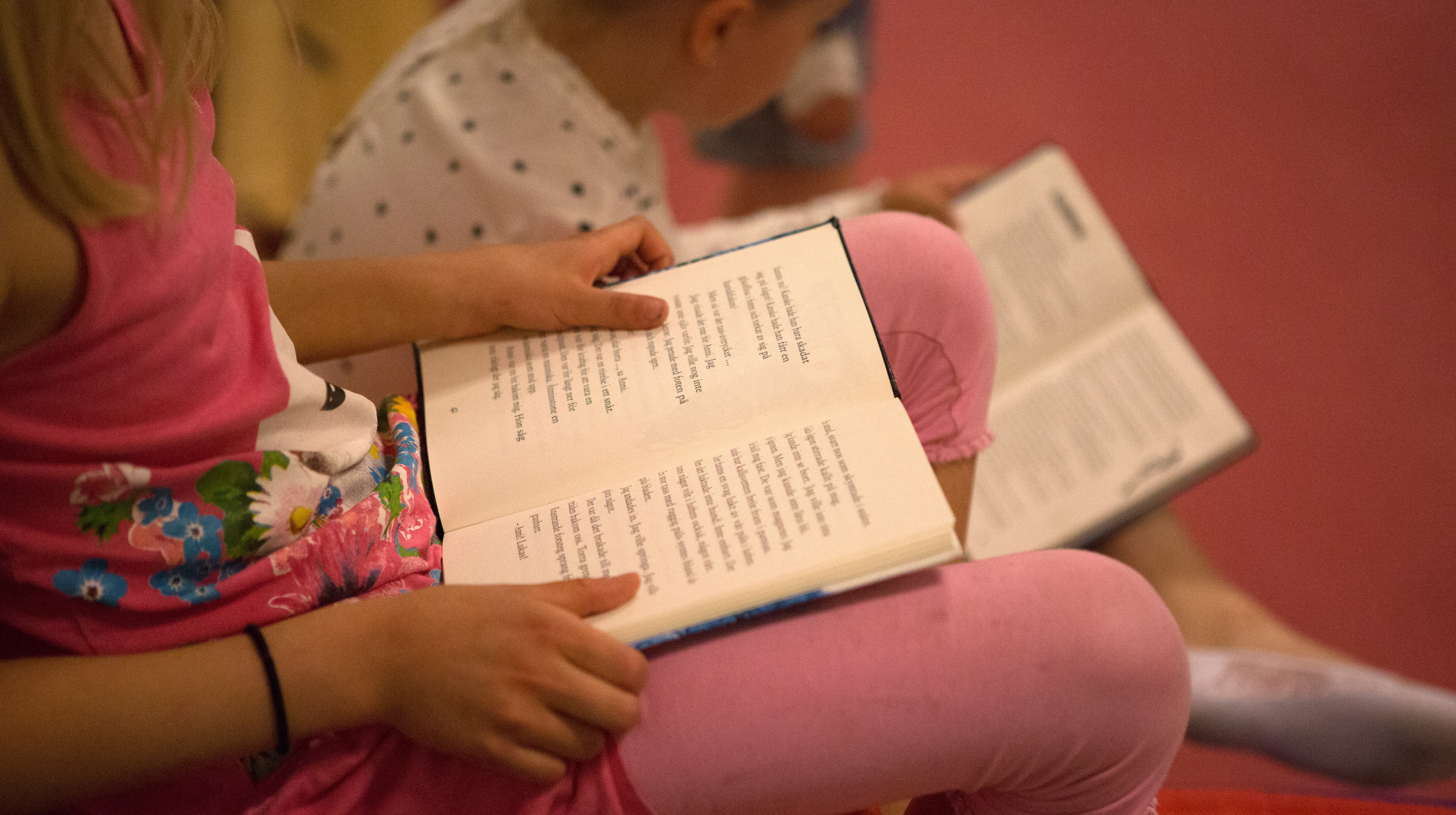 Barn läser på bibliotek. 