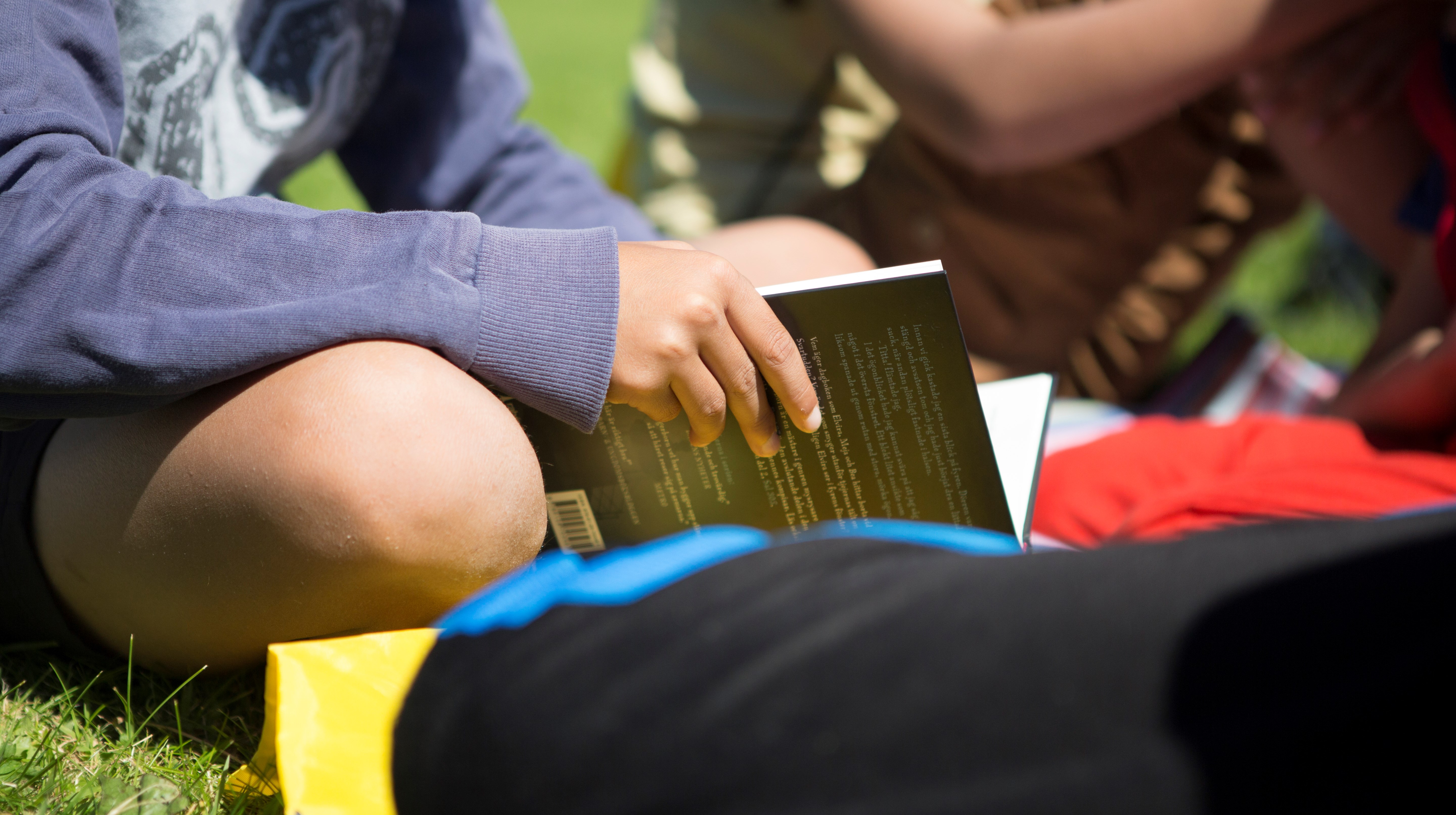 Barnhänder som håller i en bok.