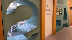 En sittplats i biblioteket, den är formad som bokstaven S och har utsikt ner mot våningen nedanför. Lite längre bort finns fler sittplatser och hyllor utformade som bokstäver.