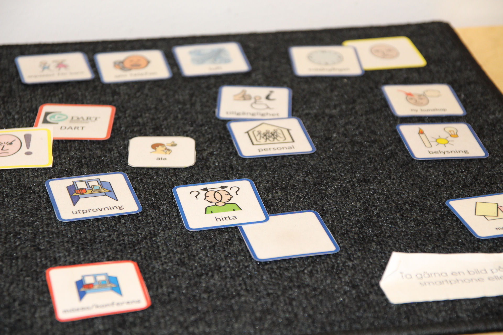 En svart dörrmatta med många färgglada bilder på