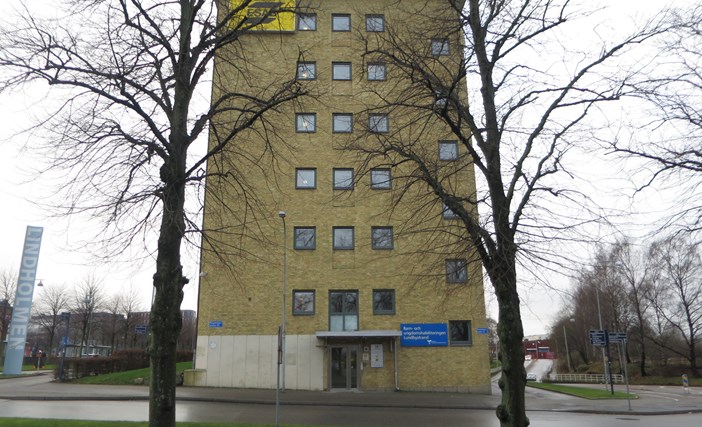 Hög gul tegelbyggnad med ingång på kortsidan